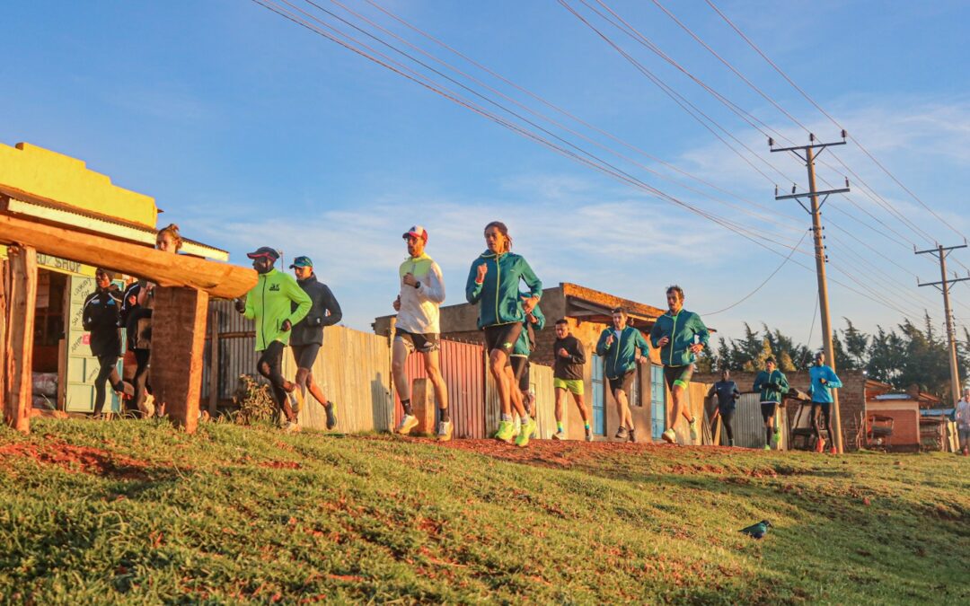 Group running past local shops in Iten